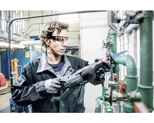 Ein Mann sägt ein Rohr mit einer Metabo Säbelsäge