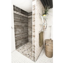 Badezimmer mit Dusche, Fliesen und Dekoartikeln für eine helle und freundliche Atmosphäre.