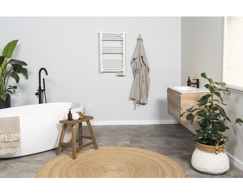 Badezimmer mit freistehender Badewanne, Waschtisch und Handtuchwärmer