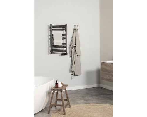 Badezimmer mit Handtuchwärmer, Handtuch, Bademantel, Hocker und Badewanne