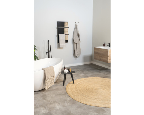 Badezimmer mit freistehender Badewanne, Handtuchwärmer, Hocker und rundem Teppich