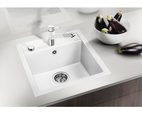 Spüle aus Silgranit mit Abtropffläche, Einhebelmischer und einigen Auberginen