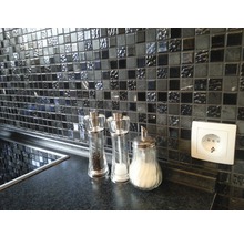 Mosaikfliesenwand in Küche mit Gewürzstreuern und Steckdose