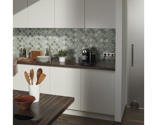 Küchenszene mit Mosaikfliesen, Küchenutensilien, Kaffeemaschine und Holztisch