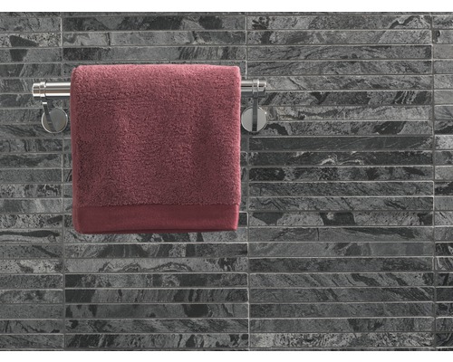 Handtuch auf Handtuchhalter vor gefliester Wand