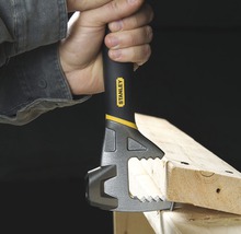 Eine Hand hält einen Stanley Multifunktions-Werkzeugkopf an einem Stück Holz.