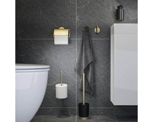 Badezimmerausstattung mit Toilettenpapierhalter, Handtuchhaken, Toilettenbürstengarnitur und Seifenspender vor dunklem Hintergrund