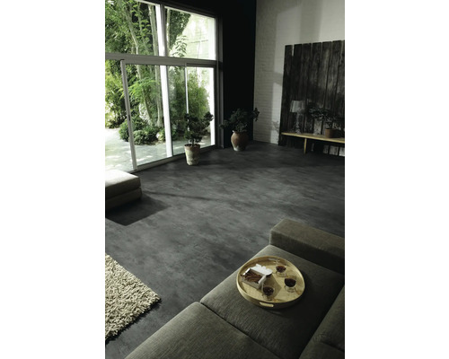 Wohnraum mit großem Fenster, grauer Boden und Zimmerpflanzen