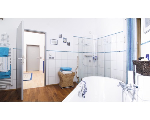 Badezimmer mit Badewanne, Dusche, Waschbecken, Heizkörper und Handtüchern