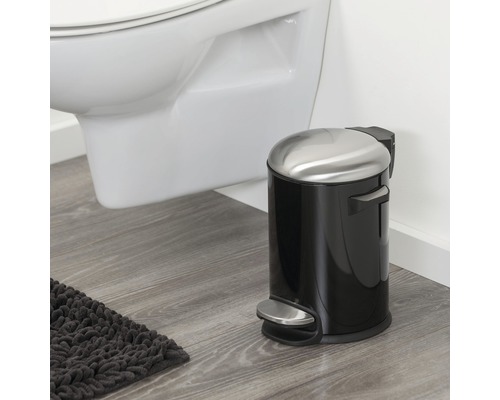 Treteimer aus Metall und Kunststoff im Badezimmer neben einer Toilette