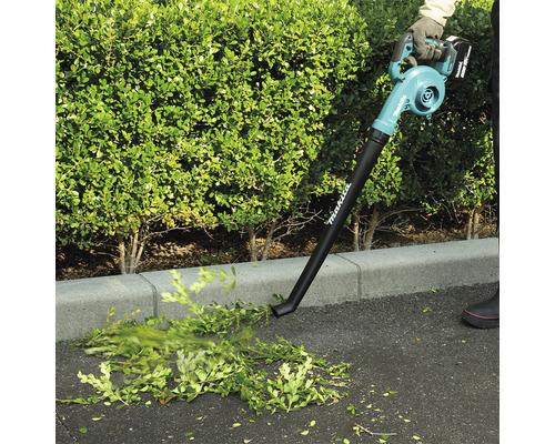 Akku-Laubbläser im Einsatz zum Entfernen von Laub und Gartenabfällen von einer asphaltierten Fläche