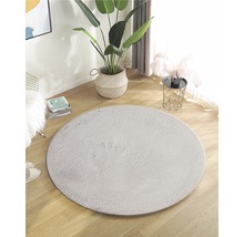 Einrichten mit rundem Teppich aus Kunstfaser auf Holzboden in einem hellen Raum.