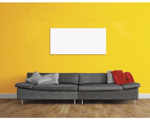 Wohnzimmer mit grauem Sofa, Kissen, Decke und einem leeren, rechteckigen Bild an der Wand