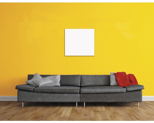Wohnzimmer mit grauer Couch, Kissen und leerem, quadratischem Rahmen an der Wand