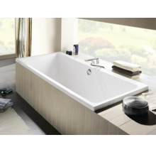 Rechteckige Badewanne im Badezimmer mit Armaturen und Handtüchern