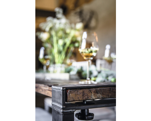 Detailansicht eines Tisches mit Metallbeinen, Holztischplatte, Blumenschmuck und Weingläsern