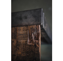 Detailansicht eines Tisches mit Tischplatte aus Metall und Tischbein aus Holz