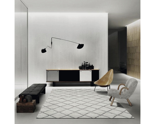 Heller Wohnraum mit Kommode, Sitzbank, Teppich und Sesseln.