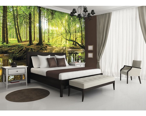 Schlafzimmer mit Fototapete eines Waldes, Bett, Nachttischen und Sitzbank