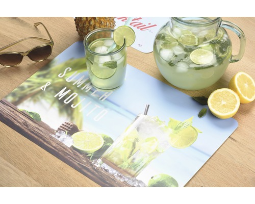 Dekoration mit Getränkekrug, Glas, Zitrone, Ananas und einer Tischdecke mit Mojito-Motiv
