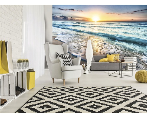 Wohnzimmer mit Fototapete eines Sonnenaufgangs am Meer, Sessel und Teppich