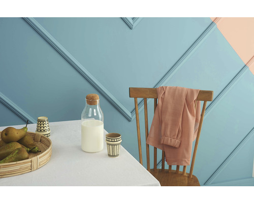 Szene mit Tisch, Stuhl, Milchflasche und Obstschale vor einer Wand mit Zierleisten