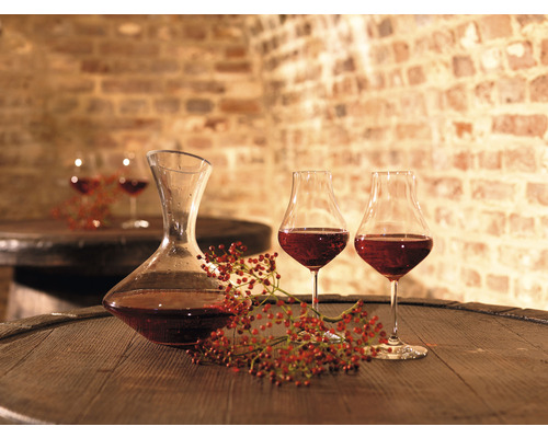 Weindekantierer und Weingläser auf Holzfass im Weinkeller