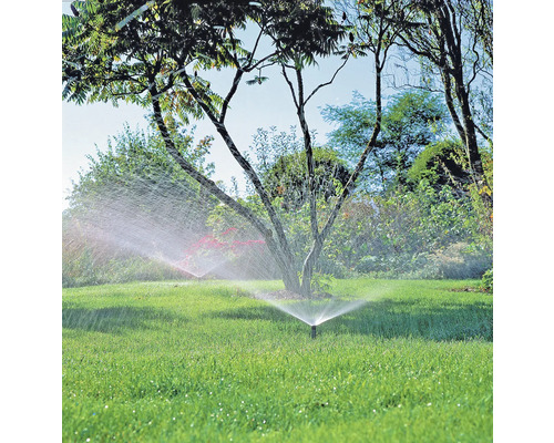 Gartenlandschaft mit Rasensprengern in Betrieb, die den Rasen bewässern