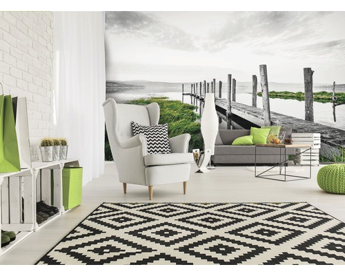 Wohnzimmer mit Fototapete, Sessel und Teppich im grafischen Design