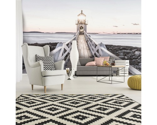 Wohnzimmer mit Fototapete Leuchtturm, Sessel, Sofa, Teppich und Beistelltisch.