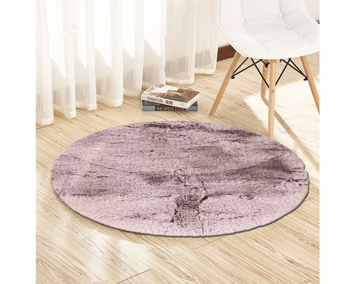 Runder Teppich auf Holzboden mit Stuhl und Büchern