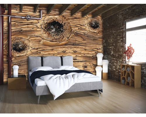Schlafzimmer mit Fototapete in Holzoptik, Bett und Nachttischen.