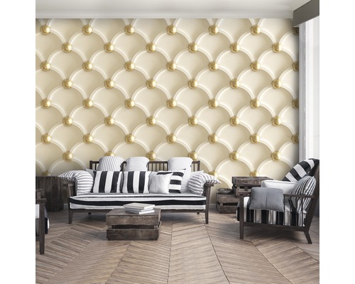 Wohnzimmer mit Couchgarnitur vor einer gemusterten Tapete in Gelb- und Goldtönen