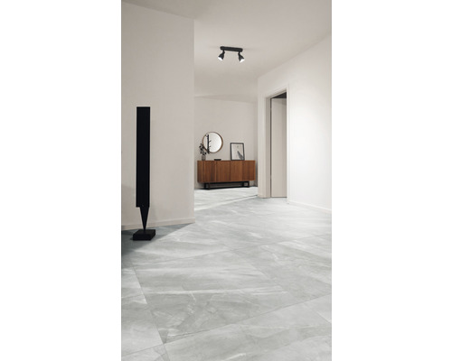 Heller Flur mit Bodenfliesen in Marmoroptik, Kommode und Skulptur.
