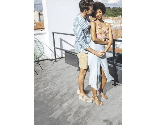 Paar umarmt sich auf einer Terrasse mit Fliesenboden