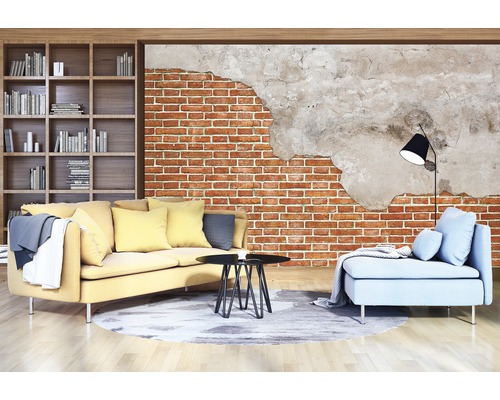 Wohnzimmer mit gelbem Sofa, blauem Sessel und Bücherregal vor einer Ziegelwandtapete