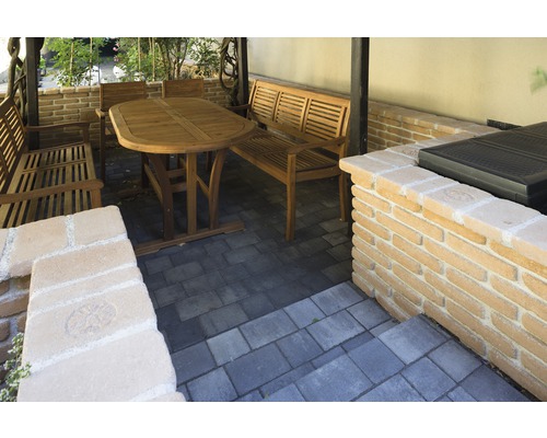 Gartenmöbel aus Holz auf Terrasse mit Pflastersteinen