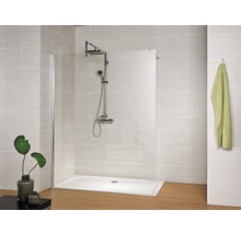 Badezimmer mit Duschkabine, Duschwanne und Armatur vor gefliester Wand