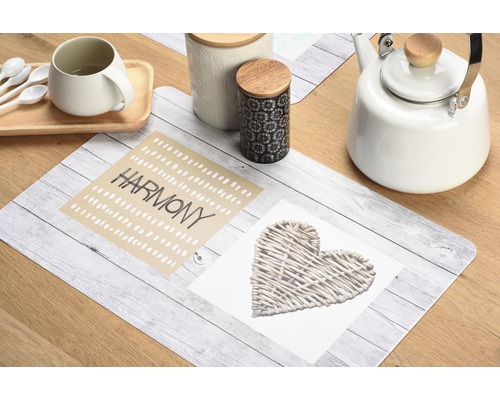 Tischdekoration mit Tischset, Tasse, Teekessel und Vorratsdosen auf Holztisch