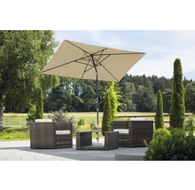 Gartenszene mit rechteckigem Sonnenschirm, Lounge-Sesseln und Tisch aus Polyrattan.