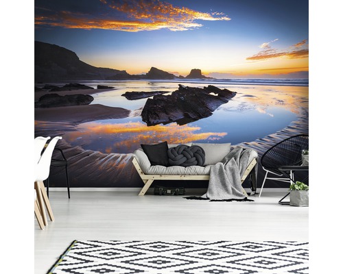 Wohnraum mit Fototapete, die einen Strand bei Sonnenuntergang zeigt.