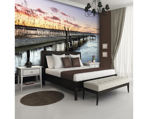 Schlafzimmer mit Fototapete mit Steg am See bei Sonnenuntergang