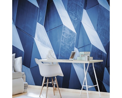 Wohnraum mit geometrischer Wandtapete, Schreibtisch und Stuhl.