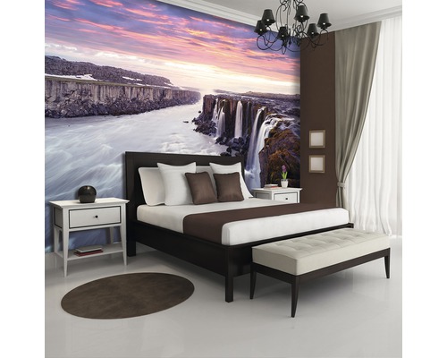 Schlafzimmer mit Fototapete eines Wasserfalls bei Sonnenuntergang, Bett und Nachttischen