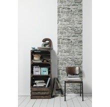 Dekoratives Zimmer mit Holzkistenregal und Steinwandtapete