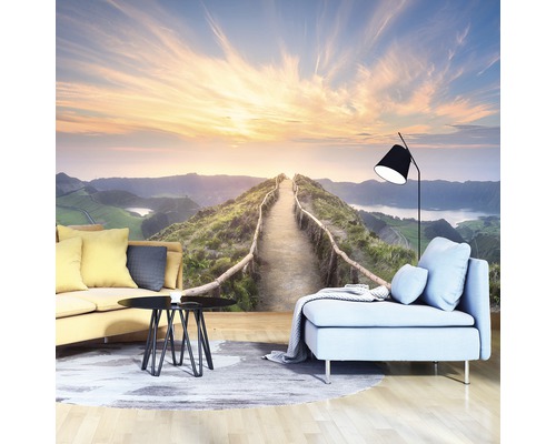 Wohnzimmer mit Fototapete, die einen Weg in den Bergen bei Sonnenaufgang zeigt