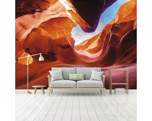 Wohnraum mit einer Fototapete, die eine Felsformation zeigt, sowie einem Sofa, einer Stehlampe und einem Regal.