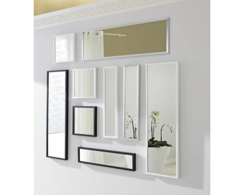 Dekorative Anordnung von Spiegeln unterschiedlicher Größe mit weißen und schwarzen Rahmen an einer Wand