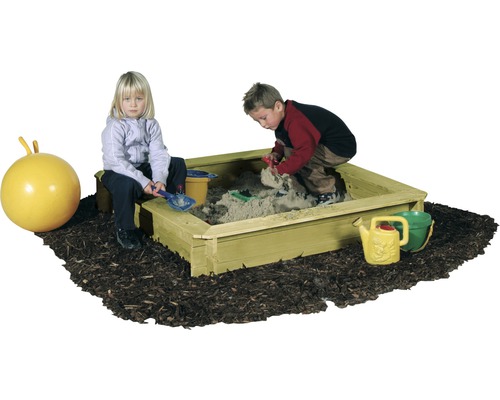 Sandkasten mit Kindern, Sandspielzeug und Hüpfball auf Rindenmulch