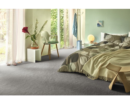 Helles Schlafzimmer mit grauem Teppichboden, Bett und Tageslicht